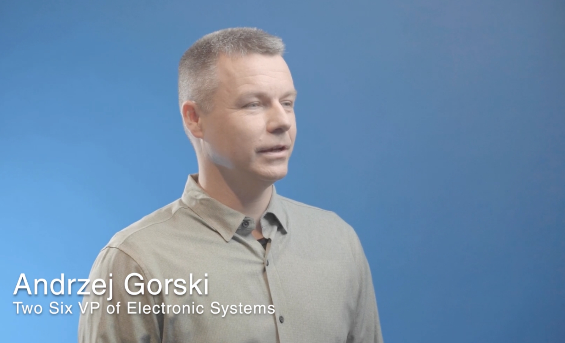 TST-Andrzej-Gorski-Video Andrzej Gorski, Vice President of Electronic Systems, speaking against a blue background.