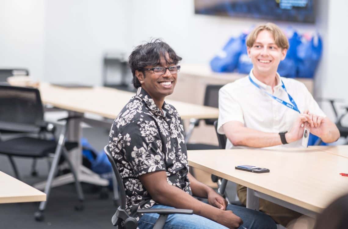 Two TST interns at the same table smiling