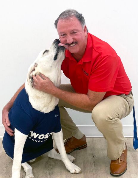 Man Getting Licked by a Dog Wearing a Shirt
